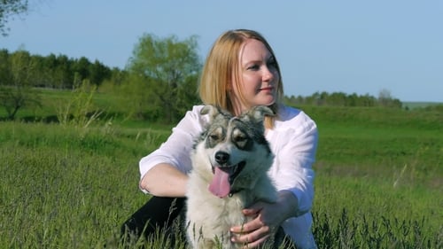 Pretty Girl Plays With a Dog on the Grass By The Lake Nature