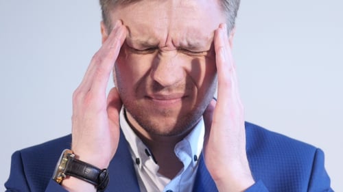 Stressed Man Massaging Temples to Relieve Headache