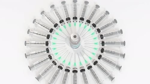 Medical Syringes Rotating Around Vaccine Vial with Zoom