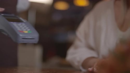Unrecognizable Woman Using Mobile Phone to Pay in Cafe