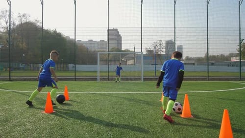 Junge Fußballspieler trainieren, um Tore zu schießen