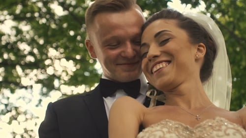 Smiling Couple Embracing on Wedding Day Outdoors
