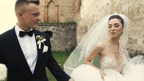 Happy Bride and Groom Walk Near Historic Building
