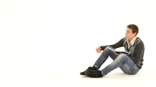 Young Adult Writes in Notebook on White Background