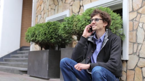 Man Talking on Smartphone Outside on Steps
