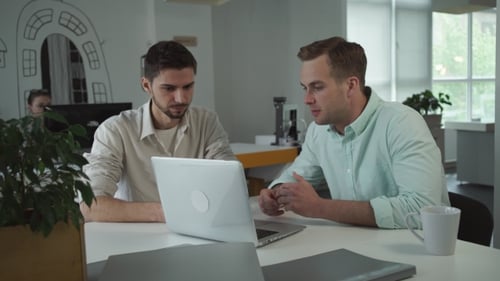 Dos jóvenes empresarios felices trabajando juntos en la oficina