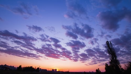 Die Bewegung der Wolken bei Sonnenuntergang, helle, satte Farben, sich schnell bewegende Wolken