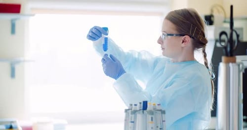 Scientist Examining Test Tube with Blue Liquid