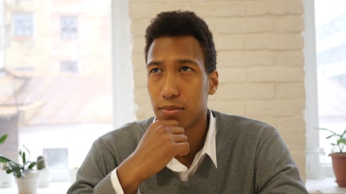 Jeune homme créatif de race mixte pensant