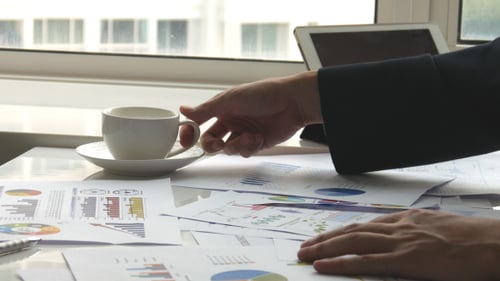 Man Reviews Financial Data at Office Desk