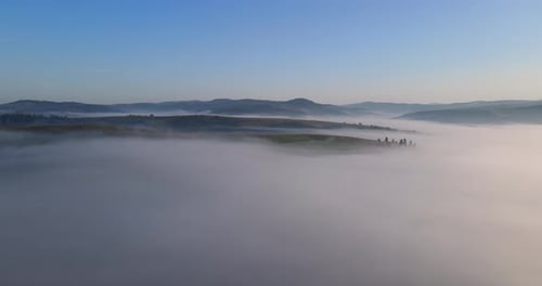 Ethereal Fog Drifting Over Hills at Sunrise