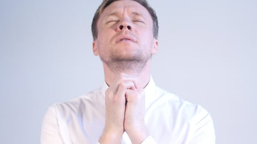 Man Clasping Hands in Prayer