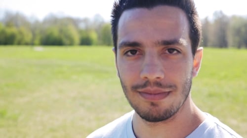 Young Man Smiling in a Green Field