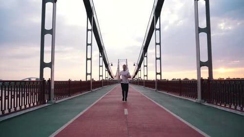 Guy Runs on a Foot Bridge in the City