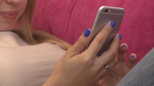 Woman Using a Mobile Phone on Pink Couch