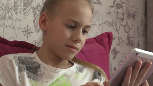 Child Using Tablet Device Sitting Indoors