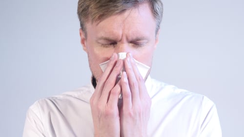 Man Blowing Nose with Tissue, Close Up