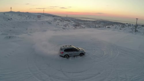 Car Drifting on Snowy Mountain at Sunrise