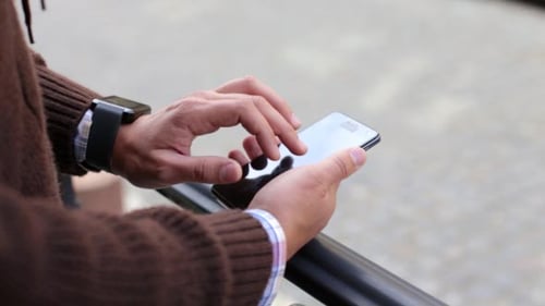 Man Using Smartphone on Urban Street, Close-up