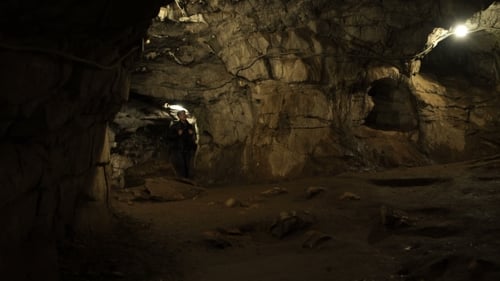 A Young Man Is Standing Inside a Rock Cave