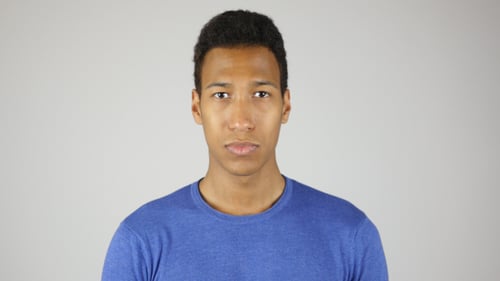 Young Man with Short Curly Hair Looks at Camera