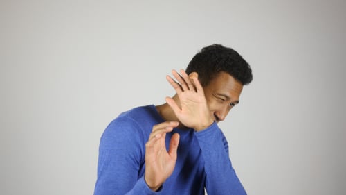 Young Man Expressing Fear with Faces and Hands