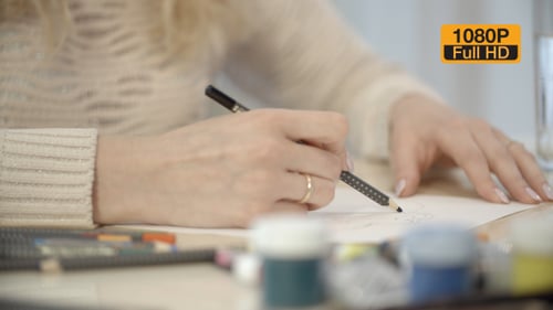 Artist Drawing on Paper with Pencil Close Up