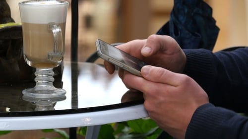 Male Hands Using Smartphone And Having Cappuccino At Cafe In Shopping Mall. Of Man Browsing