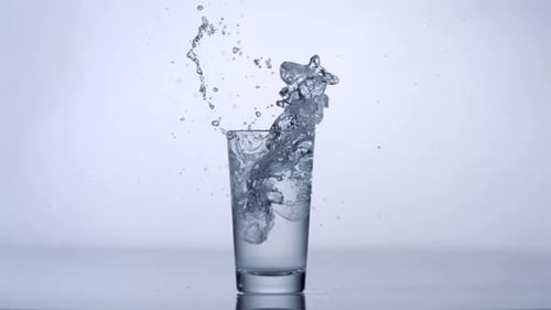 Ice Cubes Dropped into Water in Glass