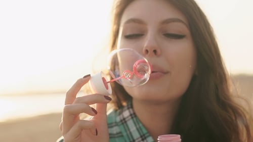 Girl Blowing Bubbles On The Beach