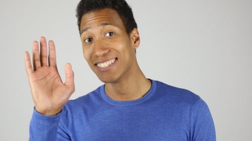 Young Man Waving Hello With a Smile