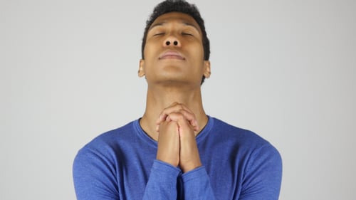 Young Man Looking Upward with Hands Clasped