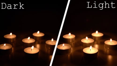 Burning Tea Light Candles Glowing in Darkness