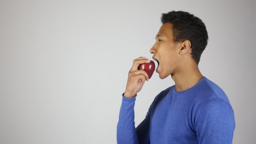 Man Eating a Red Apple Indoor