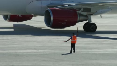 Airport Ground Crew Signals Airplane on Tarmac