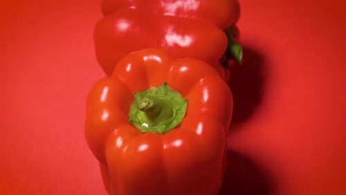 Vibrant Red Bell Peppers on Red Background
