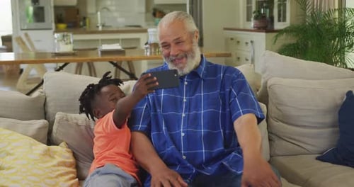 Grandfather and Child Enjoying Phone on Couch