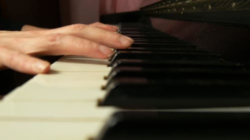 Close Up of Hands Playing a Piano