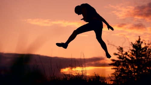 Healthy Young Man Jumping At Sunset