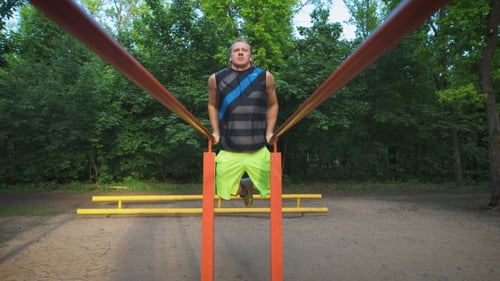 Muskulöser Mann während seines Trainings im Park. Dips, Übungen für Brust und Trizeps.