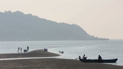 Tranquil Beach Scene with People and Boats