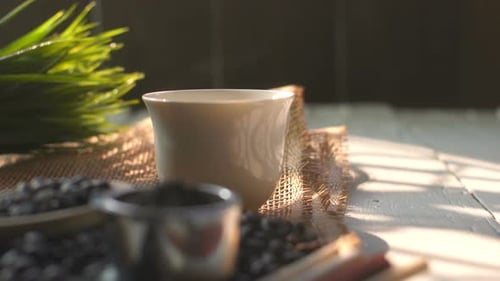 Coffee Beans with Steaming Cup in Daylight