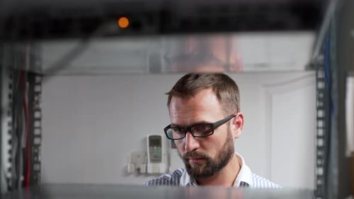 Man Working on Server Rack in Data Center