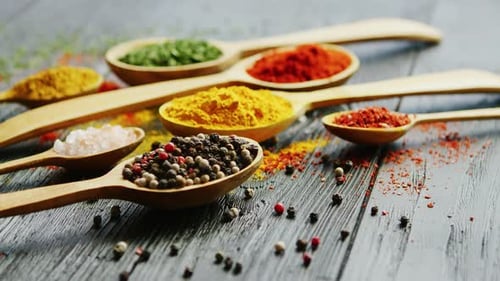 Colorful Spices in Wooden Spoons on Wood