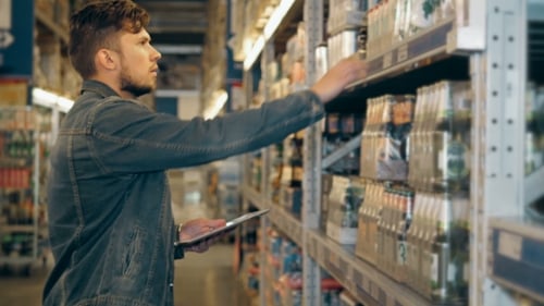Manager With Tablet PC Checking Goods at Supermarket Warehouse