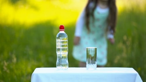 Child Pours Water Outside on Table