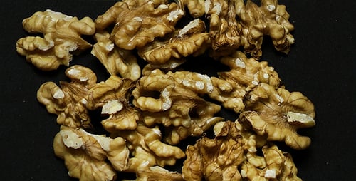 Delicious Walnut Halves Piled on a Dark Surface