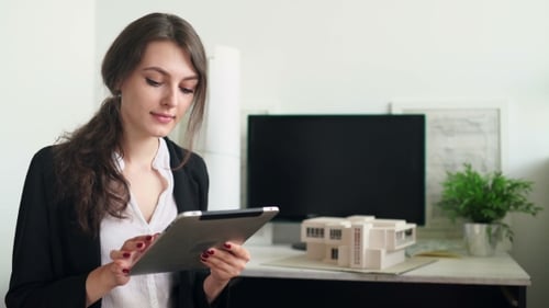 Woman Using Tablet in Modern Architecture Office