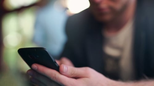 Main d'homme d'affaires travaillant à la maison ou au travail à l'aide d'un téléphone intelligent
