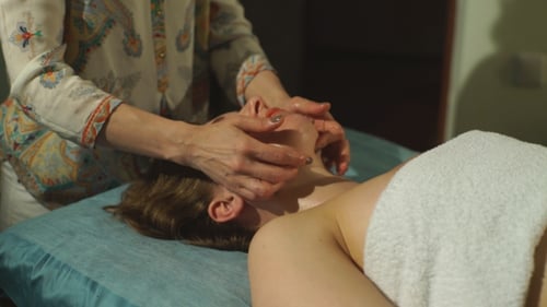 Woman Receiving Relaxing Facial Massage at Spa